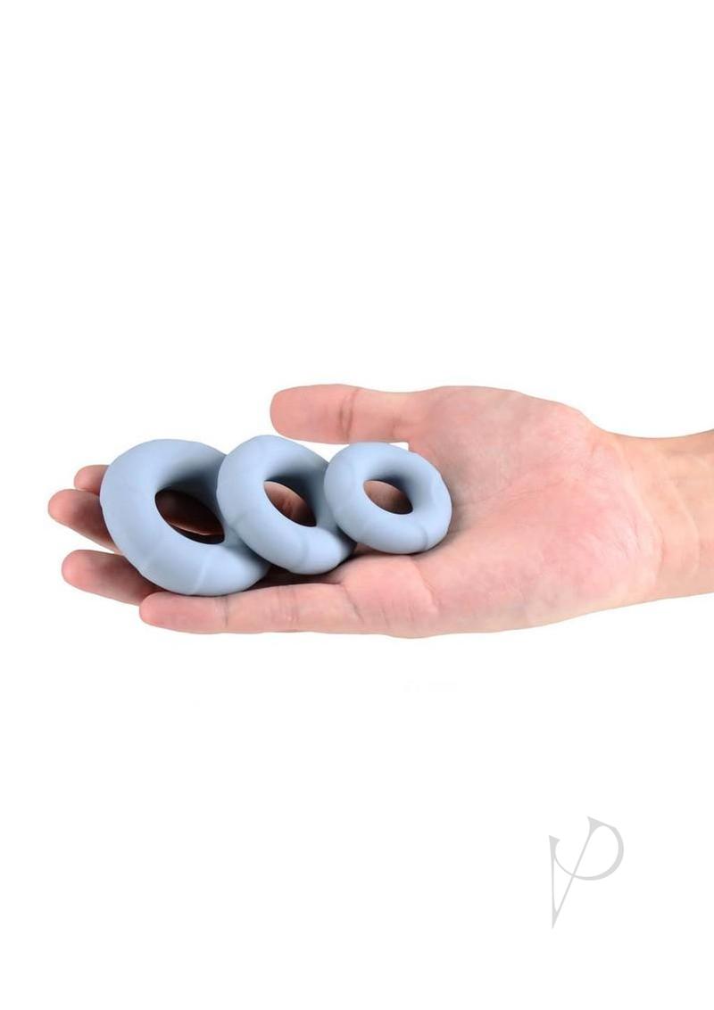 Renegade Players silicone cock rings in gray, in one hand for scale